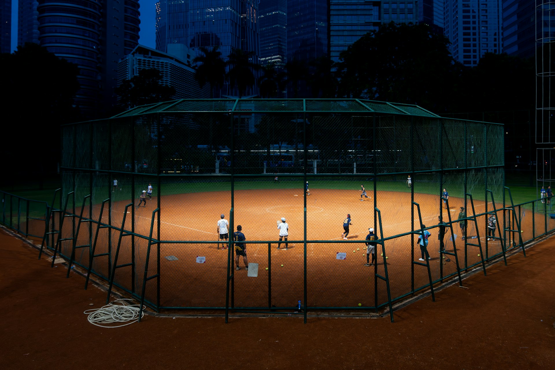 Players on a lighted softball field at night at Victory Lane Sports Park in Glendale, AZ